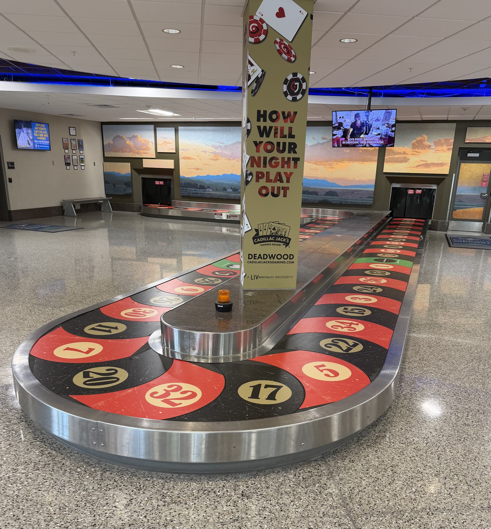 Airport baggage carousel and column with red, black and gold roulette-themed graphics